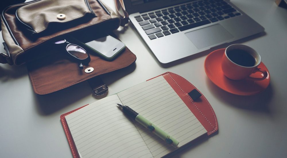 Ordinateur, café et carnet de notes
