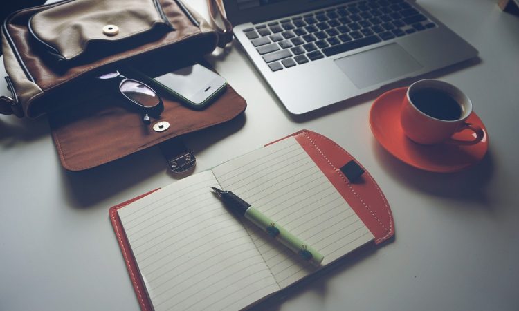 Ordinateur, café et carnet de notes