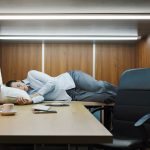 Une personne qui fait la sieste au bureau