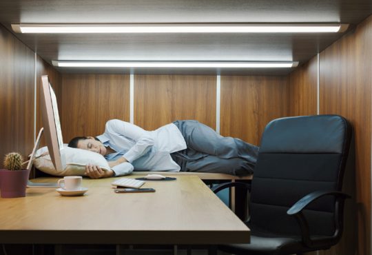 Une personne qui fait la sieste au bureau