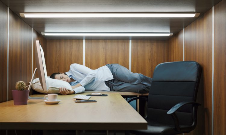Une personne qui fait la sieste au bureau