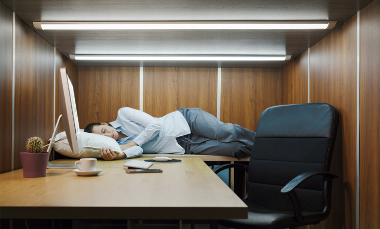Une personne qui fait la sieste au bureau