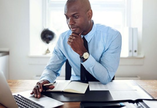 Homme devant son ordinateur qui étudie
