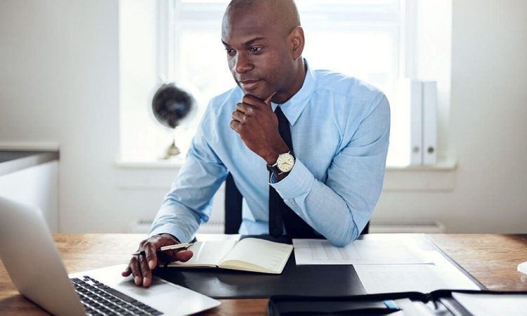 Homme devant son ordinateur qui étudie