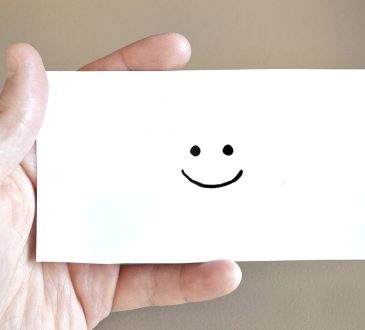 Personne qui tient une carte sourire dans ses mains