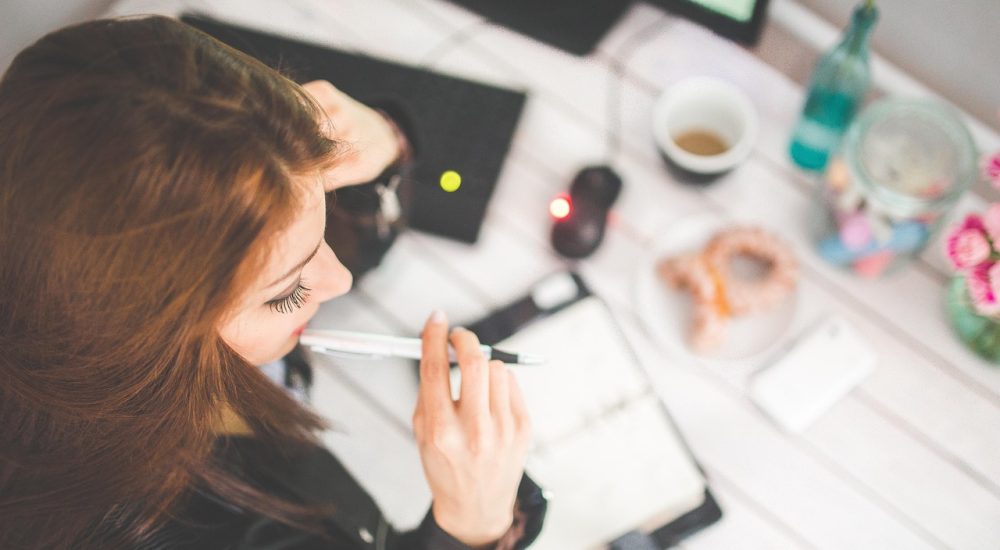 Femme au travail qui réfléchie