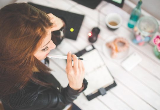 Femme au travail qui réfléchie