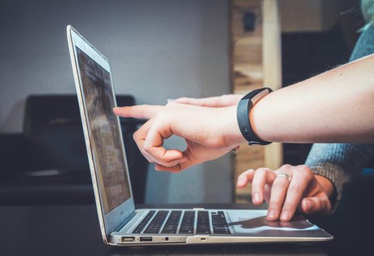 Personne qui pointe une étude sur un ordinateur